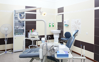 The inside area of a dental office with a dental chair and dental tools