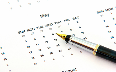 An image of a calendar with a pen sitting on it