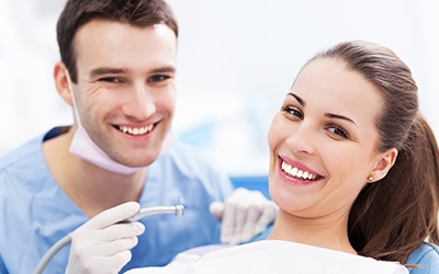 A woman smiling with dentist next to her